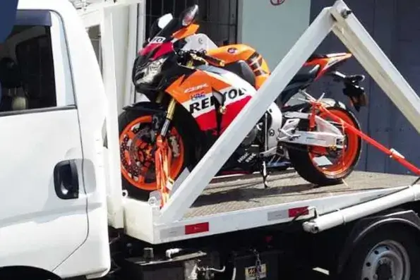 Moto presa com cintas na plataforma de um guincho. Imagem ilustrativa.