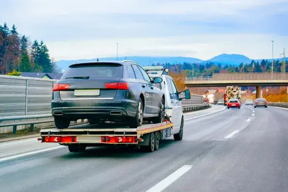SUV transportado na plataforma de um guincho em rodovia. Imagem ilustrativa.